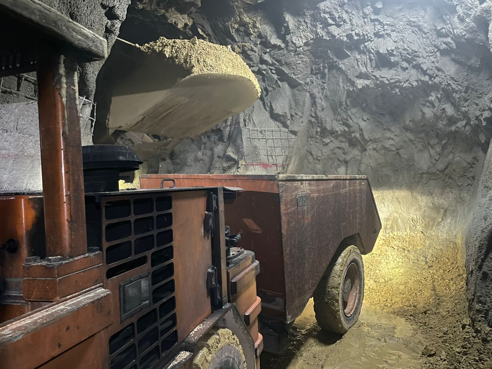 Loader filling a haul truck underground